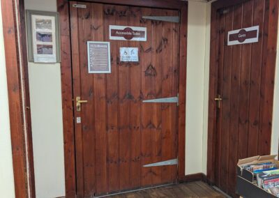 A wooden door showing a disabled toilet sign
